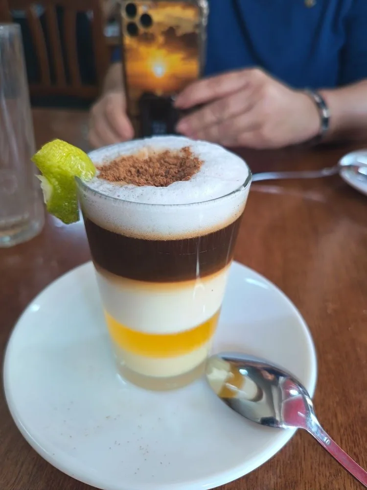 Barraquito en vaso de cristal, con sus capas de café, leche y espuma